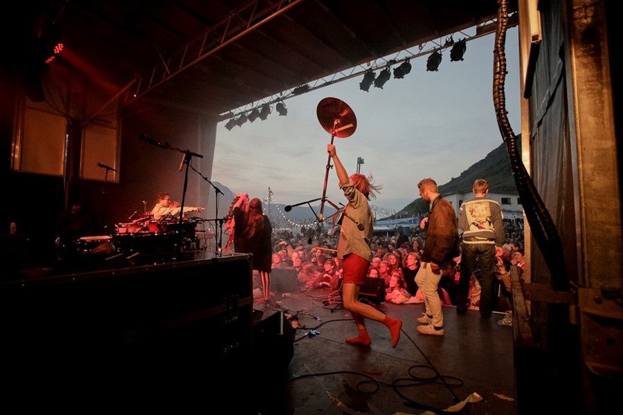 A band performs in front of a lively Icelandic crowd during one of the country’s iconic summer music festivals.