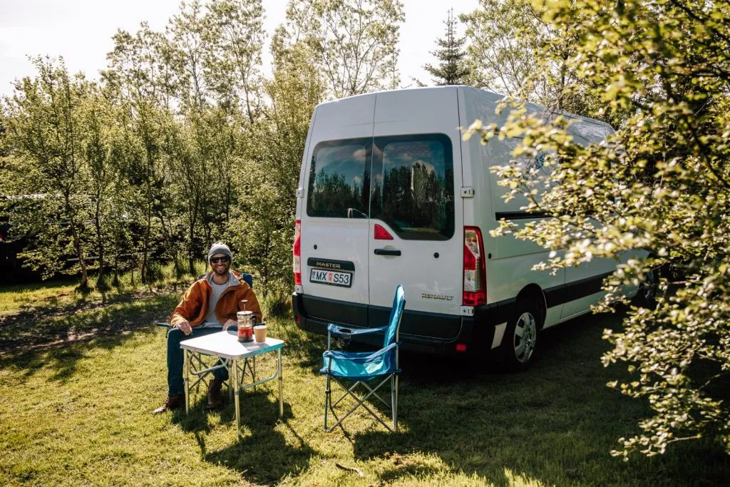 Campervan parked at a campsite in Iceland with outdoor table, capturing the comfort and flexibility of van travel