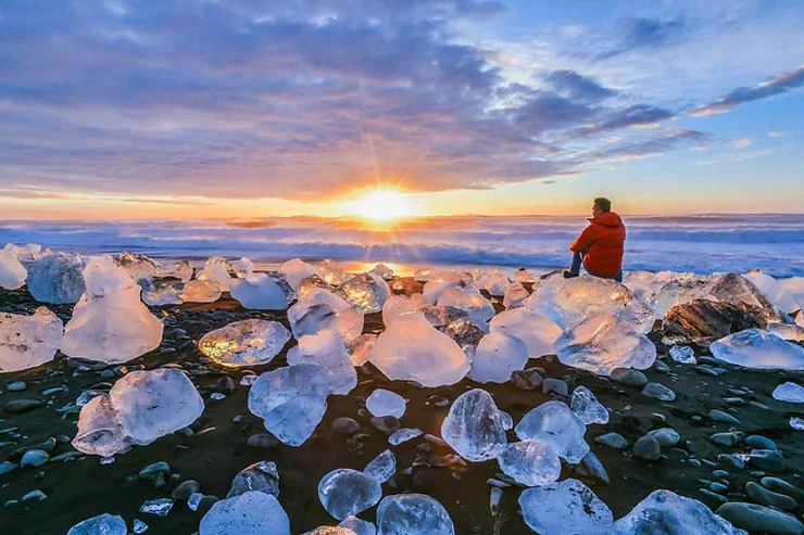 Ice chunks on black sand beach in Iceland, glowing like nature is flexing