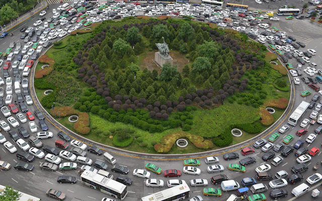 Huge Roundabout Jam in Urban Area Aerial view of a massive traffic jam surrounding a large roundabout in a busy city.