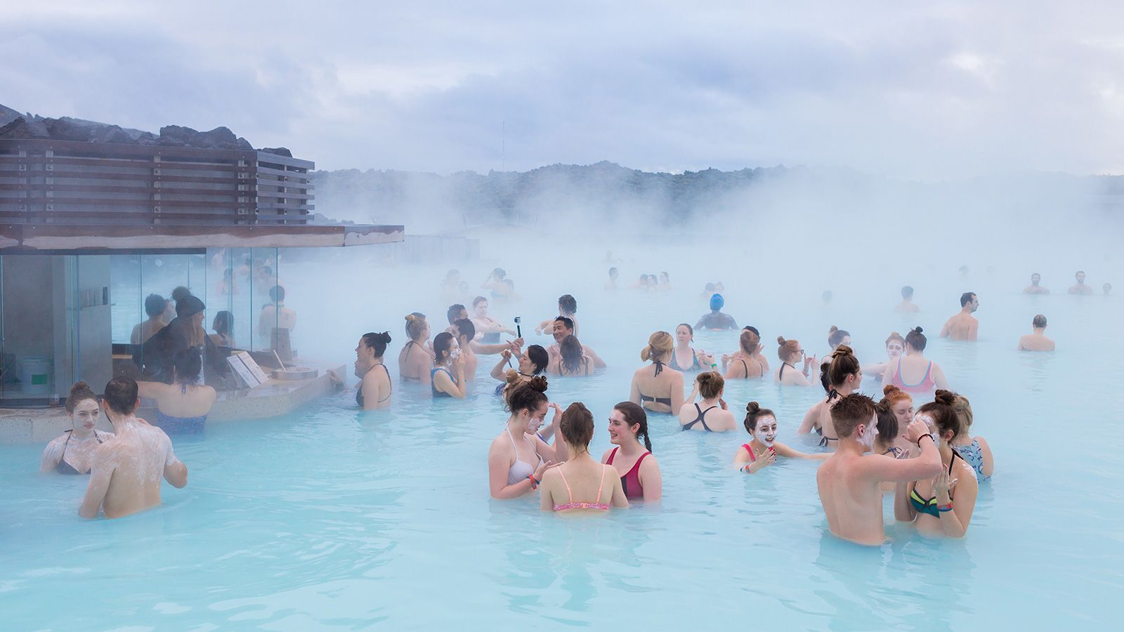 Visitors sipping drinks in the Blue Lagoon, Iceland’s iconic geothermal spa with a built-in bar and steamy views.