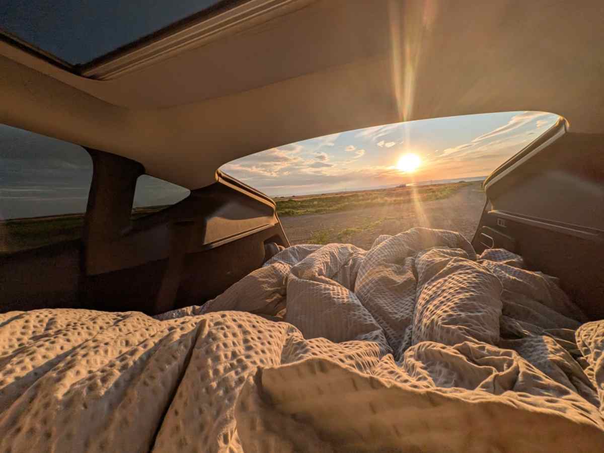 Warm bedding inside a campervan in Iceland during sunset on a scenic road trip.