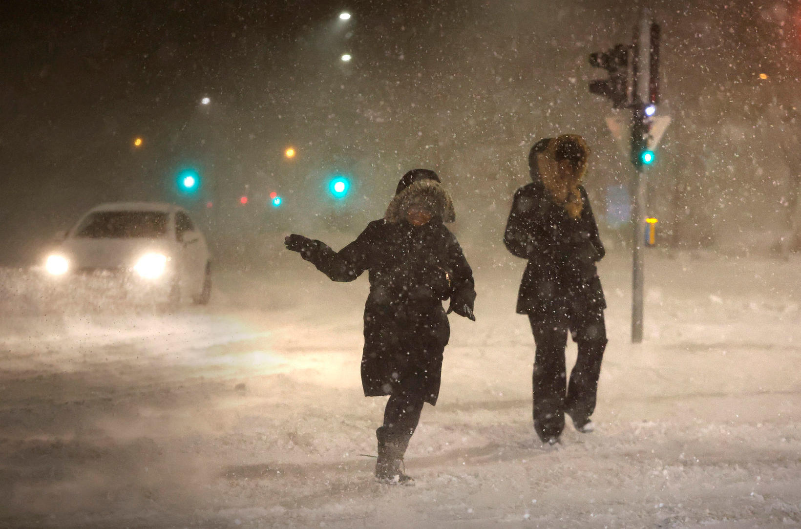 Two people fight their way through a heavy Icelandic snowstorm, a scene every winter traveler eventually learns to navigate with style and frozen eyelashes.