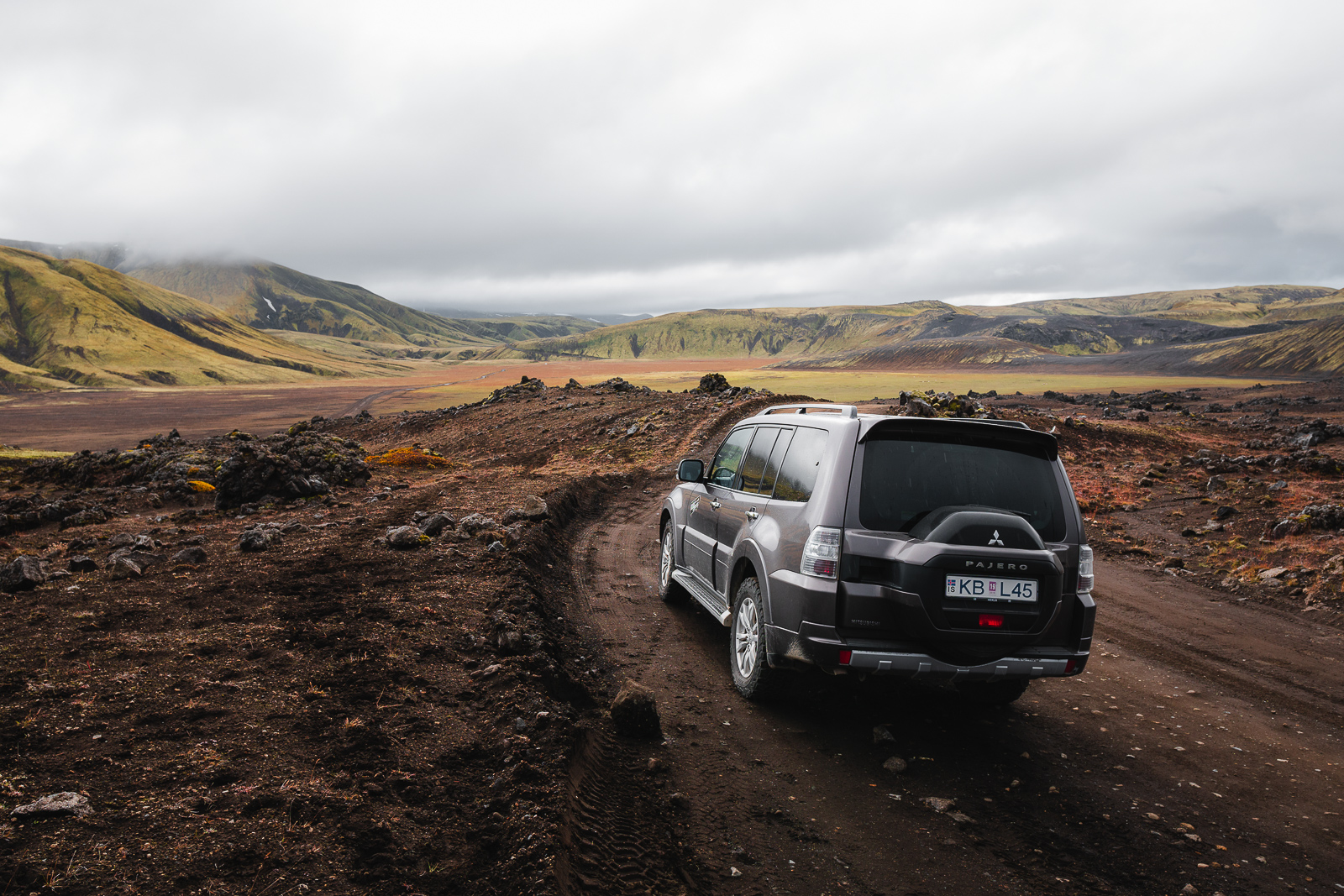 A 4x4 camper navigates a rugged gravel road in Iceland, where gravel protection insurance is essential to avoid damage from loose volcanic rocks.
