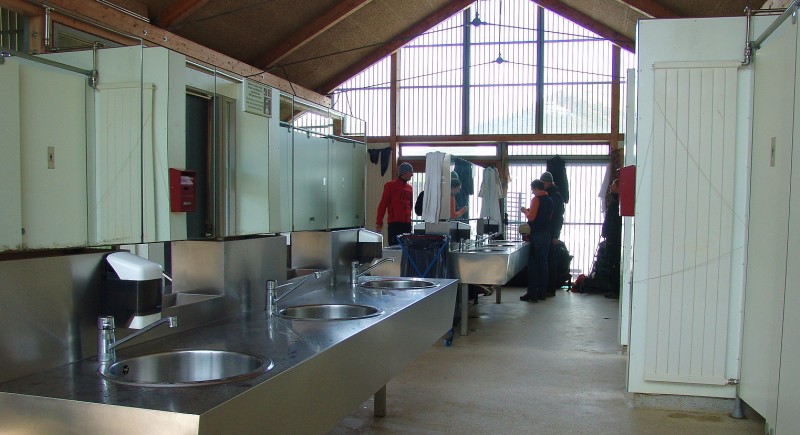 Shared bathroom and shower area in an Iceland campsite with sinks, changing spaces and camper facilities.