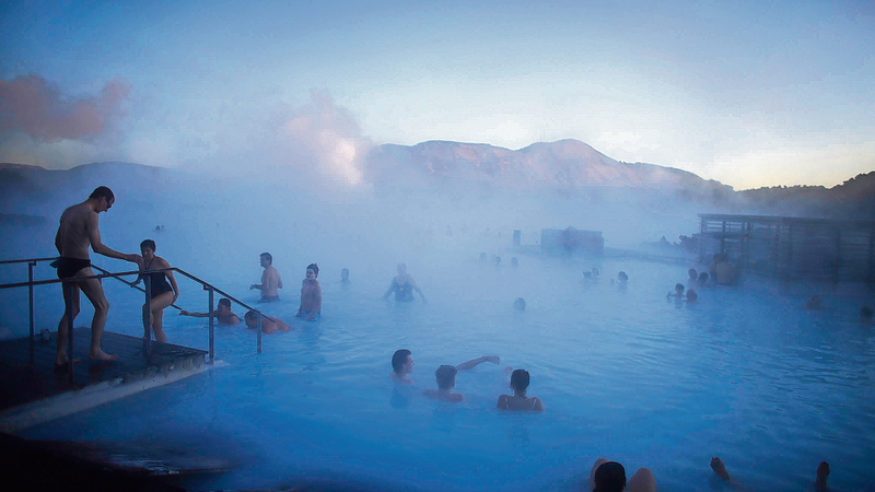 People relaxing in a geothermal pool in Iceland, showing hot water sources that are not suitable for drinking.